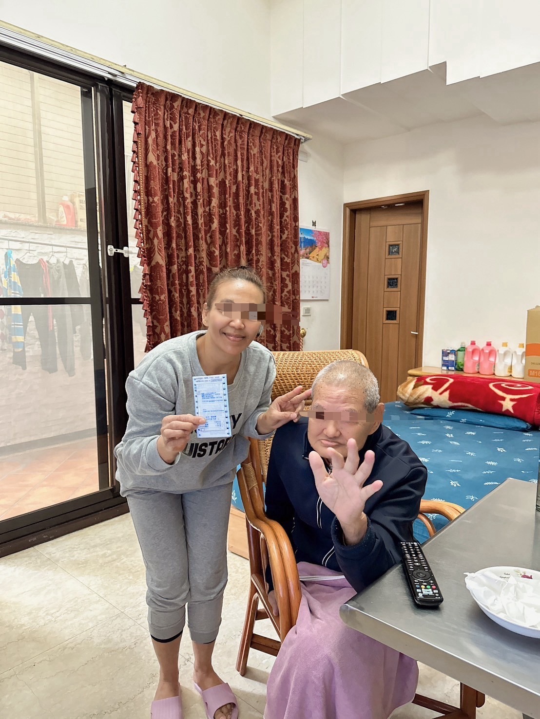 一名護理人員向一位老人展示一張彩券。 每日家庭護理訪問。