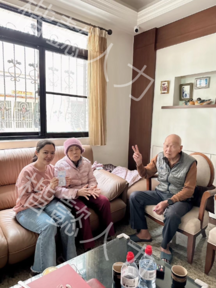 一家三代人，包括一名護理人員，一起坐在沙發上。 選擇合適的護理人員是關鍵。